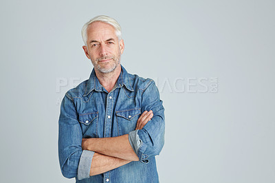 Buy stock photo Studio portrait of a handsome mature man standing with his arms crossed