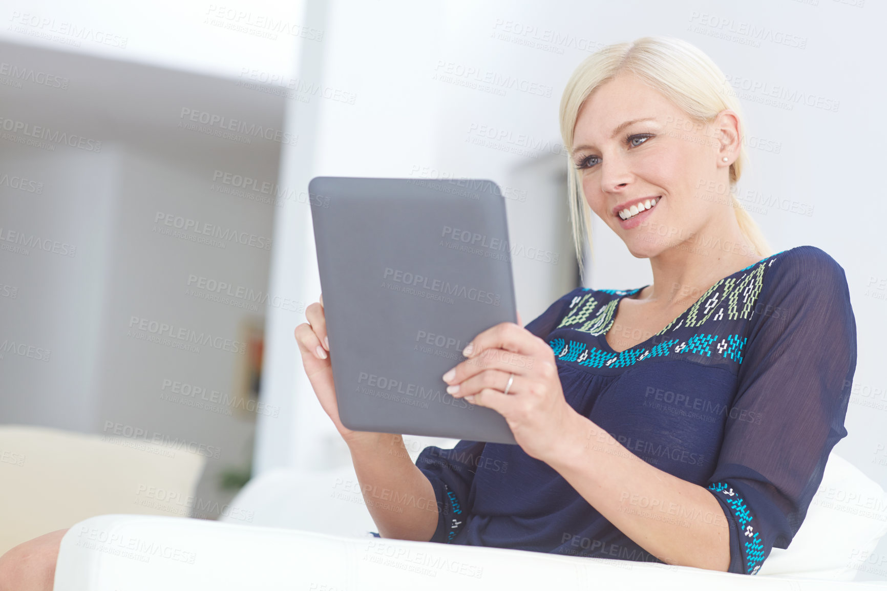 Buy stock photo Shot of a beautiful woman sitting with a digital tablet at home