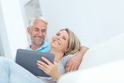 Buy stock photo Senior, tablet and couple on a house couch on technology laughing and watching a movie on tech, Home, sofa and mature people in love with care smile about internet meme or social media scroll