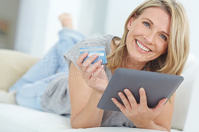 Buy stock photo Portrait of a happy mature woman doing some online shopping at home using her digital tablet