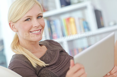 Buy stock photo Portrait of a beautiful woman sitting with her tablet on the sofa at home