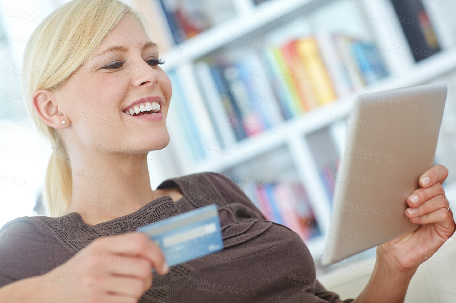 Buy stock photo Shot of a beautiful woman doing some online shopping at home using her digital tablet