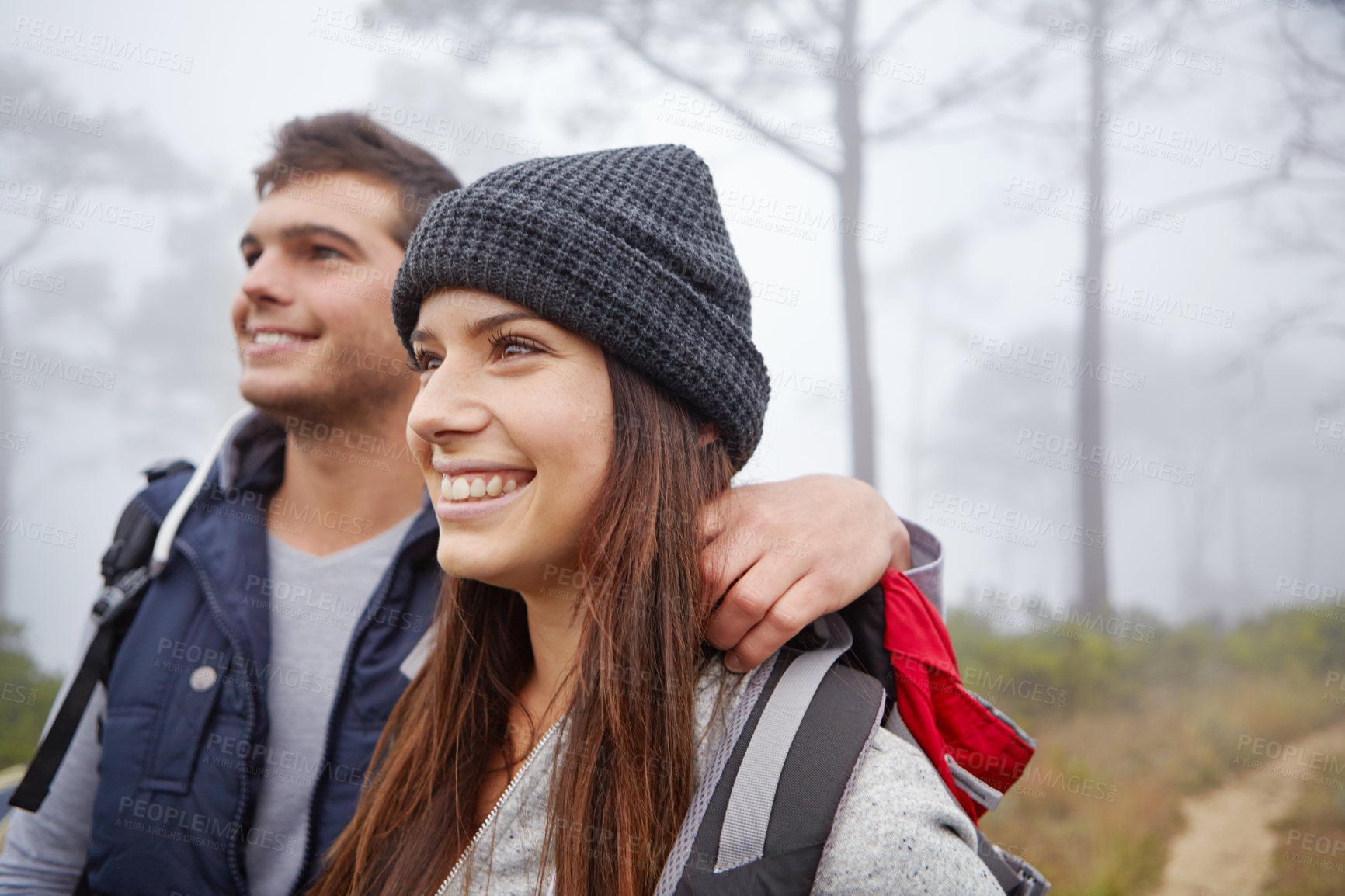 Buy stock photo Shot of an affectionate young couple enjoying the view while out hiking