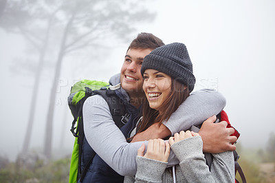 Buy stock photo Shot of an affectionate young couple enjoying the view while out hiking