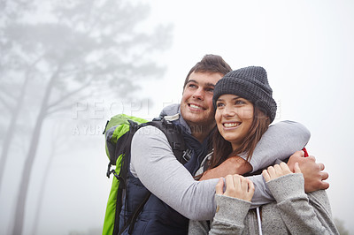 Buy stock photo Shot of an affectionate young couple enjoying the view while out hiking