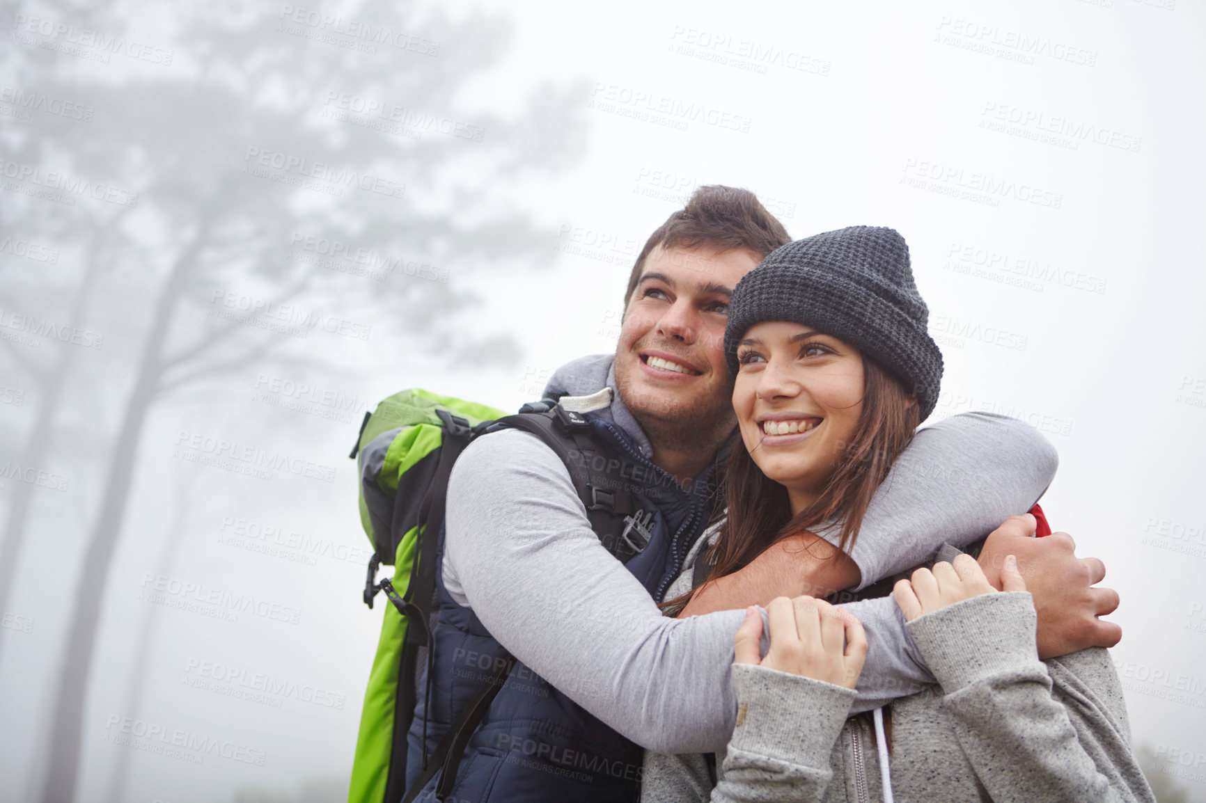 Buy stock photo Shot of an affectionate young couple enjoying the view while out hiking