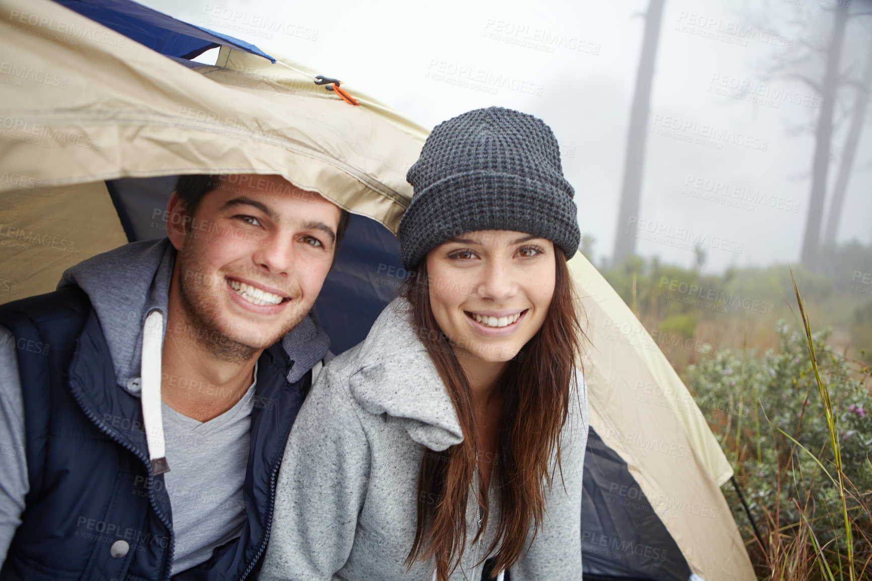 Buy stock photo Portrait of a young couple sitting inside their tent while on a camping trip