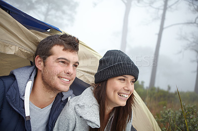 Buy stock photo Shot of a young couple sitting inside their tent while on a camping trip