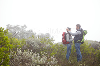 Buy stock photo Shot of a young couple being affectionate while out hiking in nature