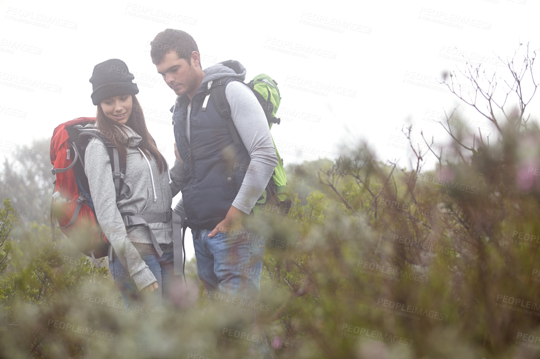 Buy stock photo Shot of a young couple enjoying a hiking trip