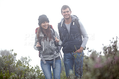 Buy stock photo Shot of a young couple hiking through nature