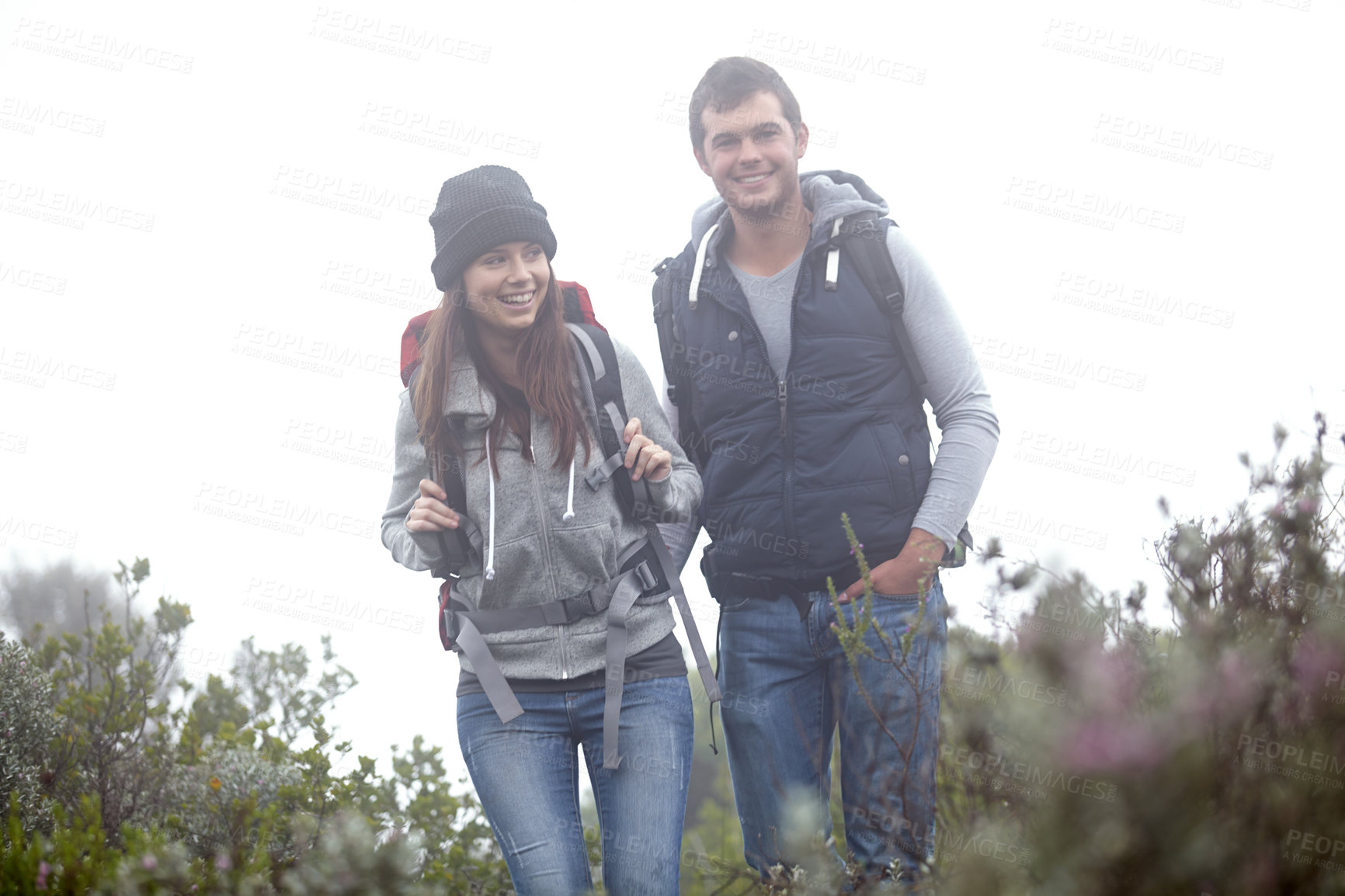 Buy stock photo Shot of a young couple hiking through nature