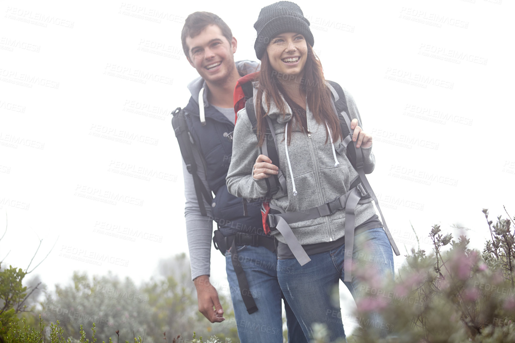 Buy stock photo Shot of a young couple hiking through nature