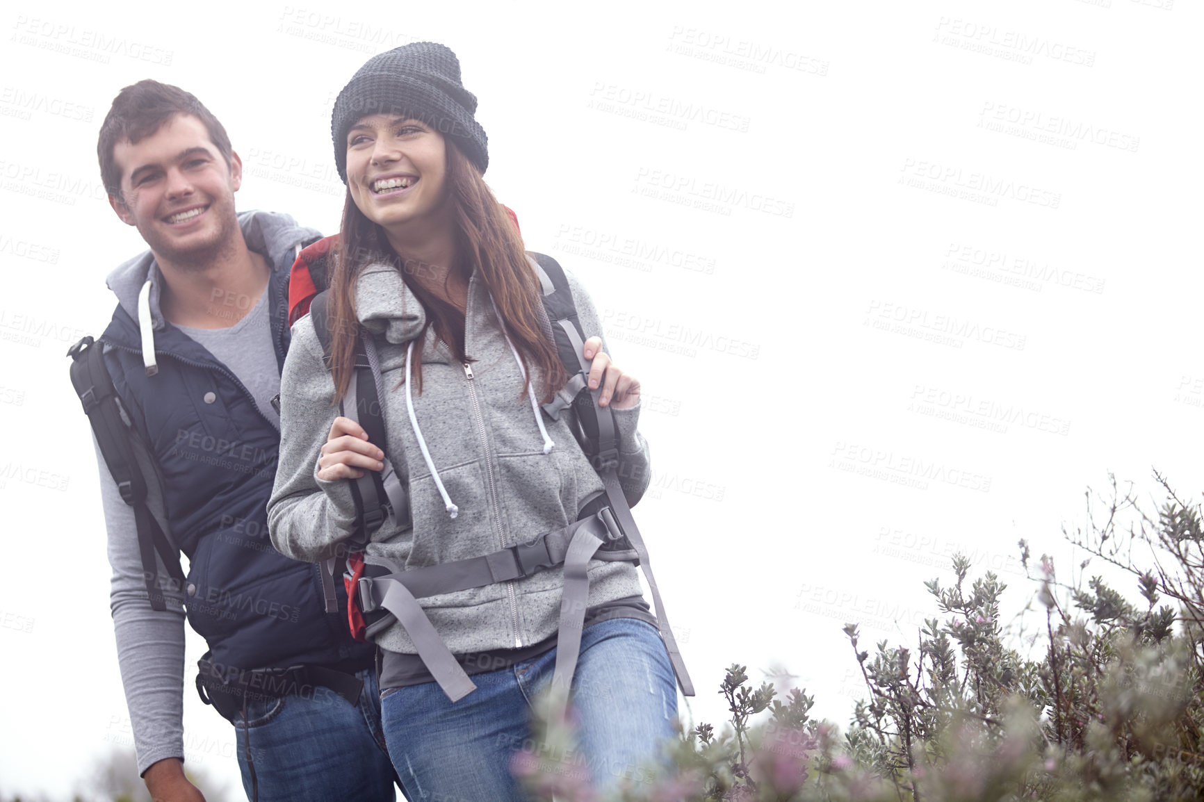 Buy stock photo Shot of a young couple hiking through nature