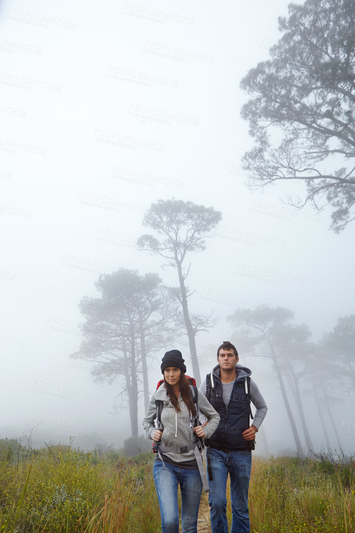 Buy stock photo Shot of a young couple hiking through nature