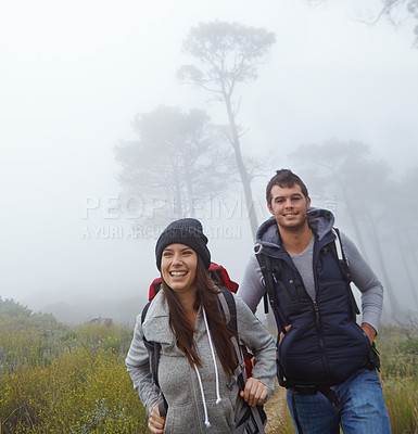 Buy stock photo Shot of a young couple enjoying a hike through nature