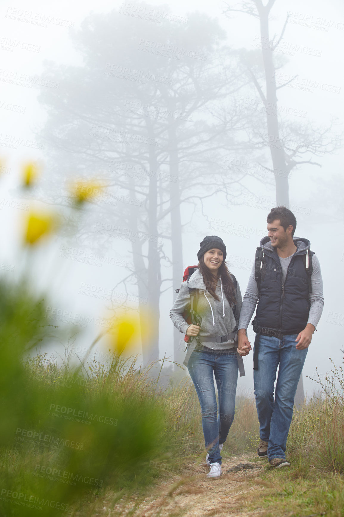 Buy stock photo Full length shot of a young couple hiking along a nature trail