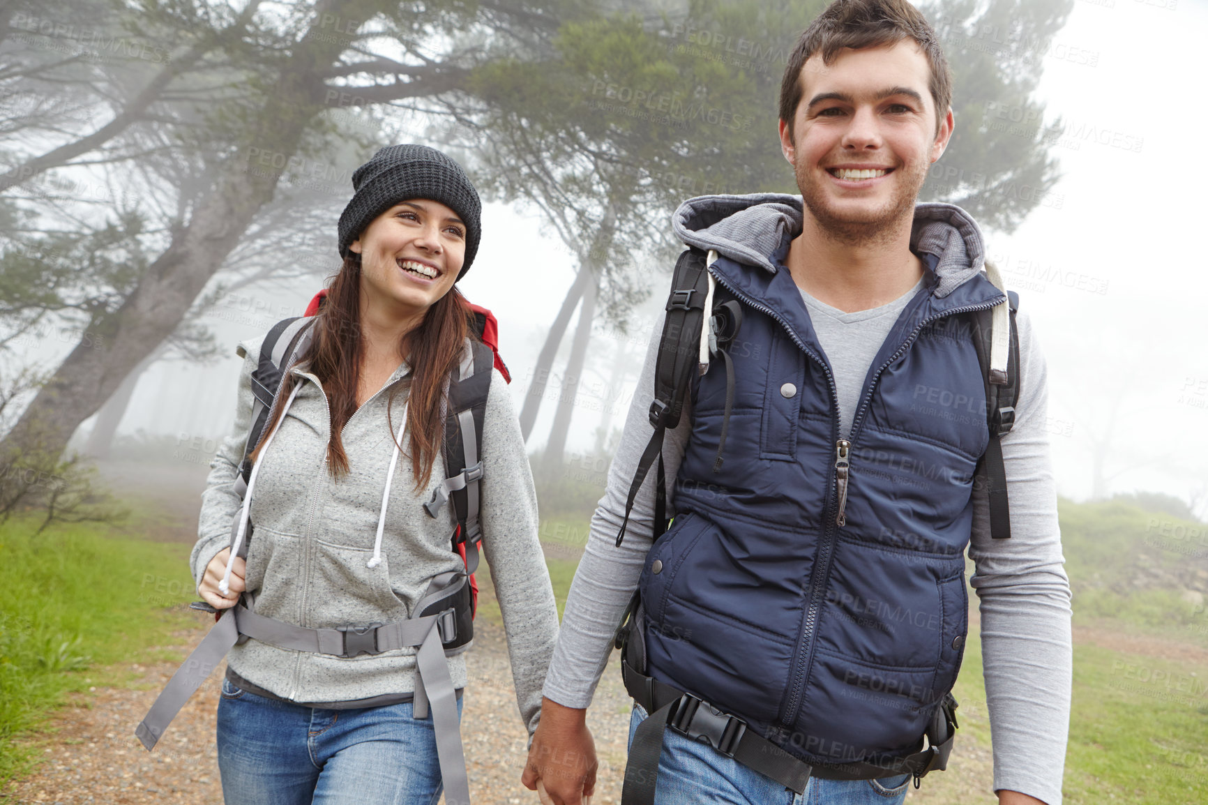 Buy stock photo Shot of a handsome young man hiking through a forest with his girlfriend