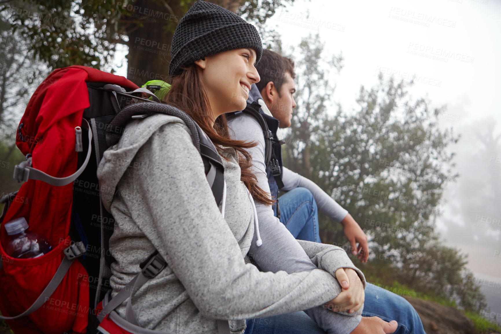 Buy stock photo Shot of a young couple sitting down for a rest while out hiking