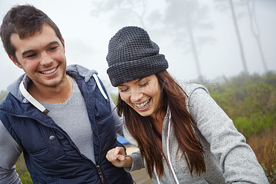 Buy stock photo Shot of a happy young couple enjoying a hike through nature