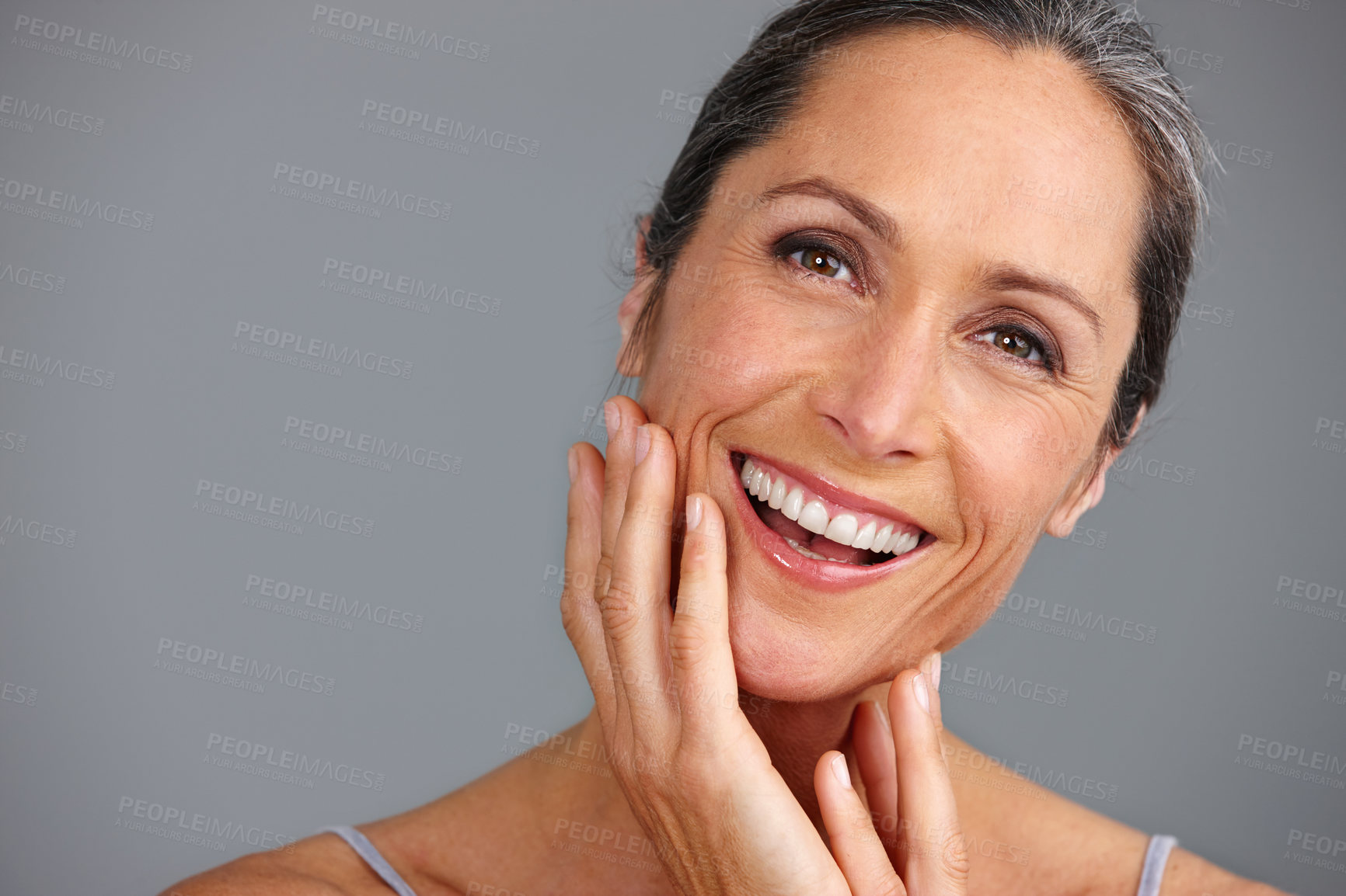 Buy stock photo Studio portrait of a beautiful mature woman posing against a gray background