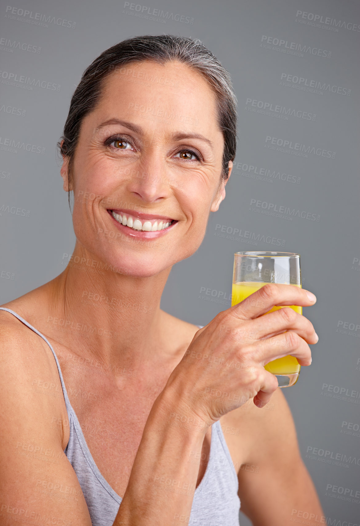 Buy stock photo Happy woman, portrait and juice with vitamin C for orange drink, diet or beverage in studio on a gray background. Mature, female person or model with smile for citrus liquid, health and wellness