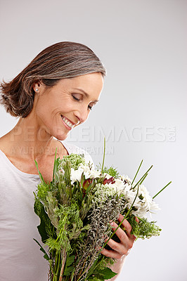 Buy stock photo Bouquet, studio and mature woman with smile, thinking and happy with gift, mothers day and celebration. White background, birthday and bunch of flowers for person, joy and contemplating with present