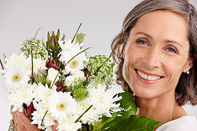 Buy stock photo Mature woman, studio and happy with flowers on portrait with confidence for gift or present on white background. Female person, smile and joy or satisfied with roses for appreciation and care