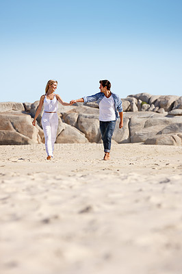 Buy stock photo Couple, holding hands and walking on sand for love, travel and summer vacation to beach. Woman, happy man and gesture at ocean for trust, commitment or security in relationship with sky space in Bali