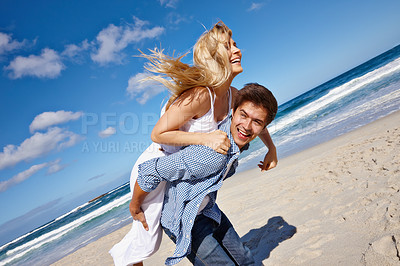 Buy stock photo Couple, walking and piggyback at beach for travel, bonding and tropical holiday with smile on sand. Man, woman and romance outdoor for trip, love and vacation with sunshine, relax or date in Thailand