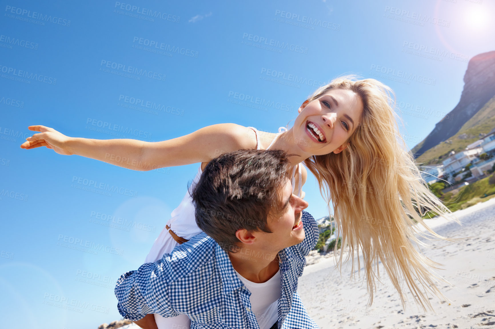 Buy stock photo Happy couple, flying and joy with beach for piggyback, holiday or weekend together in nature. Young, man and woman with smile on back for summer time, bonding or outdoor getaway by ocean coast or sea