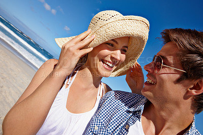 Buy stock photo Shot of a happy young couple enjoying a day at the beach