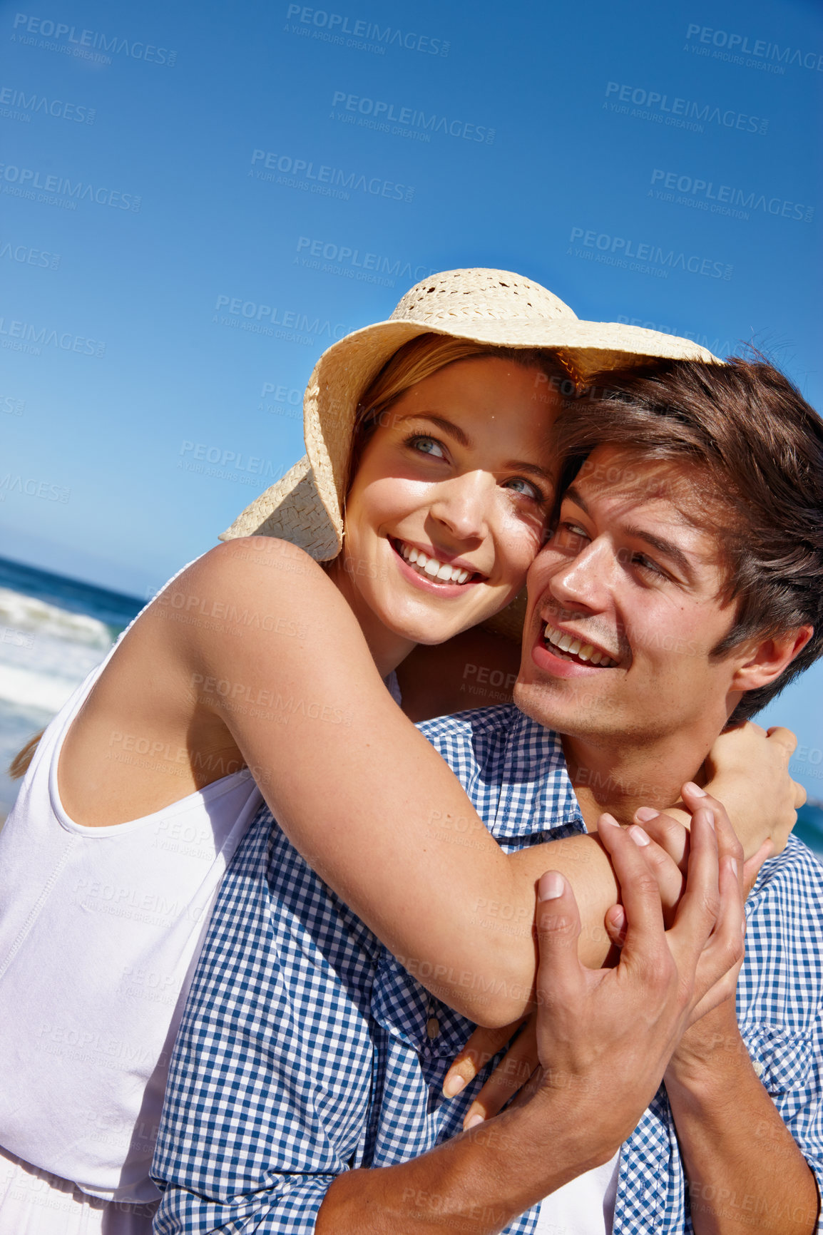 Buy stock photo Shot of a happy young couple enjoying a day at the beach