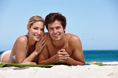 Buy stock photo Portrait of a happy young couple enjoying a day at the beach