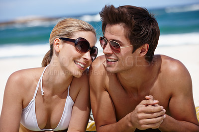 Buy stock photo Shot of a happy young couple enjoying a summer's day at the beach