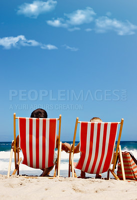 Buy stock photo Back view, chair or couple at beach with space to relax on vacation, valentines day or holiday. Sunbathe, mockup or people at sea for bonding or tanning at ocean on romantic trip on island in Greece