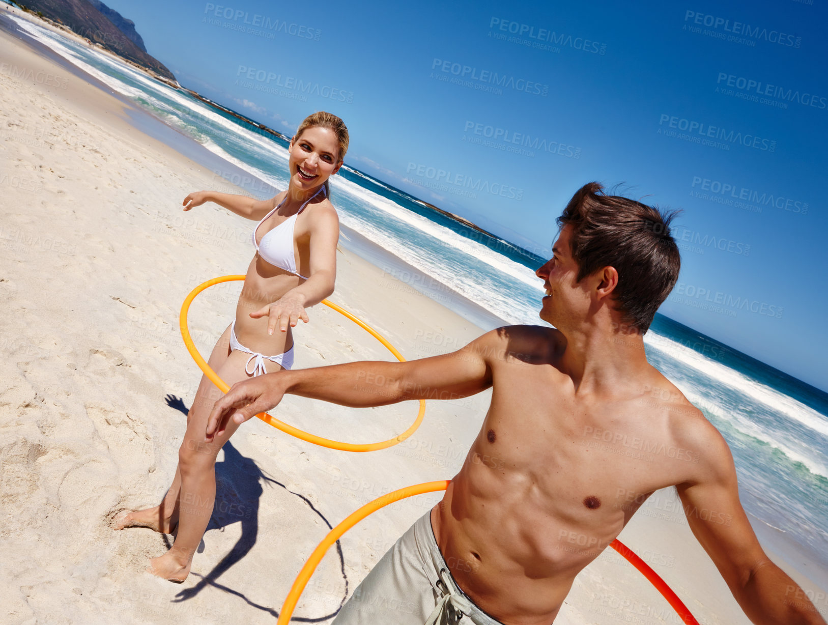 Buy stock photo People, plastic hoop and beach play by waves together for fun, holiday or bonding with core exercise in nature. Happy couple, game and Miami ocean with vacation, adventure and travel with trip