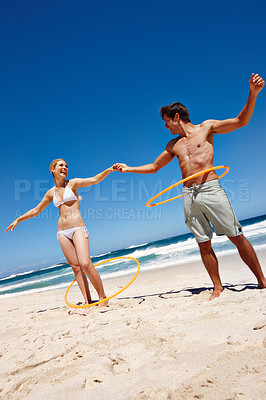 Buy stock photo People, plastic ring and beach play by waves together for fun, holiday or bonding with core exercise in nature. Happy couple, game and Miami ocean with vacation, adventure and travel with trip