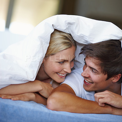 Buy stock photo Love, couple and happy with duvet in bed, comfortable and bonding with connection in relationship. Bedroom, man and woman with fabric for relax, trust and commitment with dating in morning at home