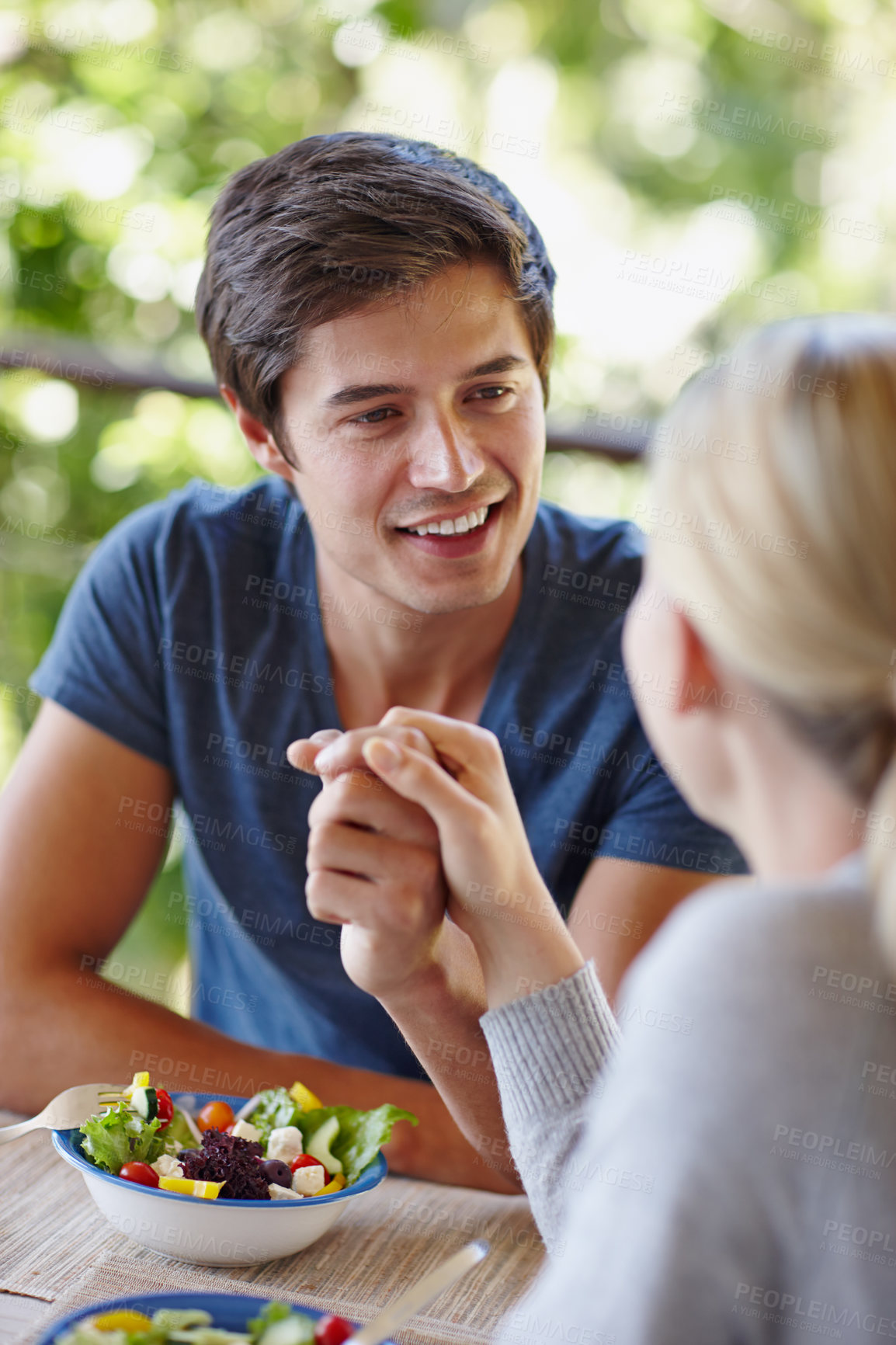 Buy stock photo Happy, couple and holding hands on home balcony with salad, lunch and outdoor on date. Man, smile and love with eating, wellness and care together with nutrition on patio with romance on table