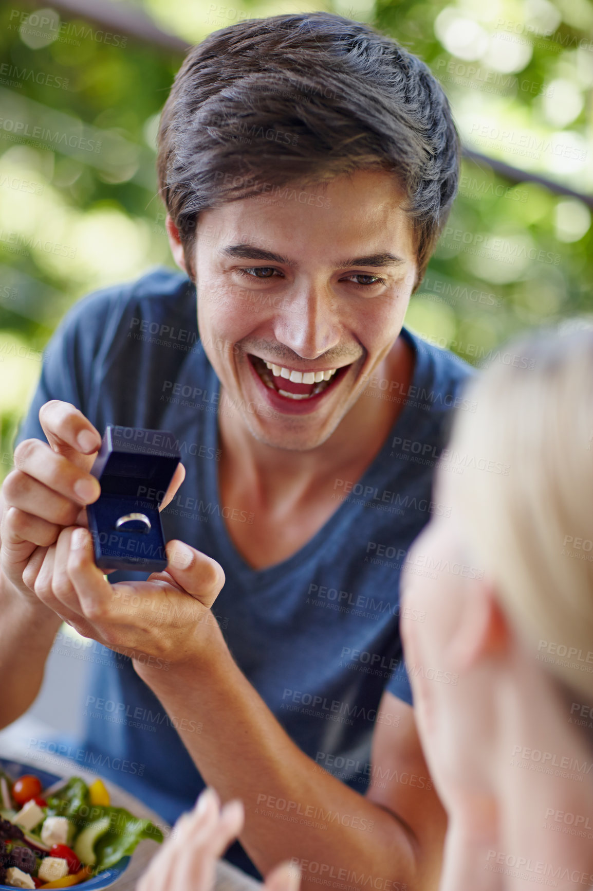 Buy stock photo Shot of a handsome young man proposing to his girlfriend with an engagement ring