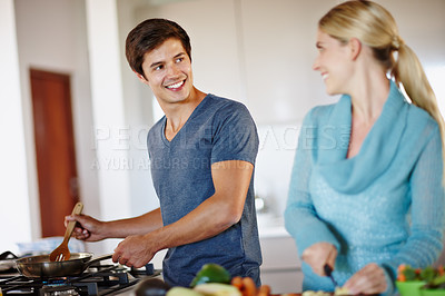 Buy stock photo Shot of a happy young couple cooking a meal together at home