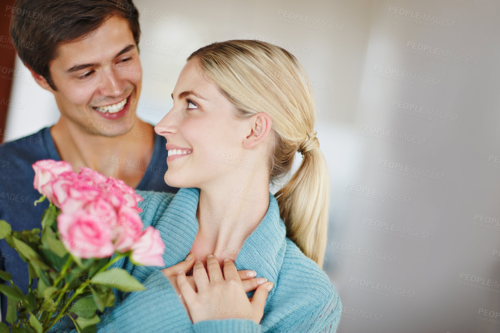 Buy stock photo Couple, home and happy with flowers for love, care and affection as lovers for valentines day. People, relationship and smile or satisfied with roses for romance, appreciation and respect to embrace