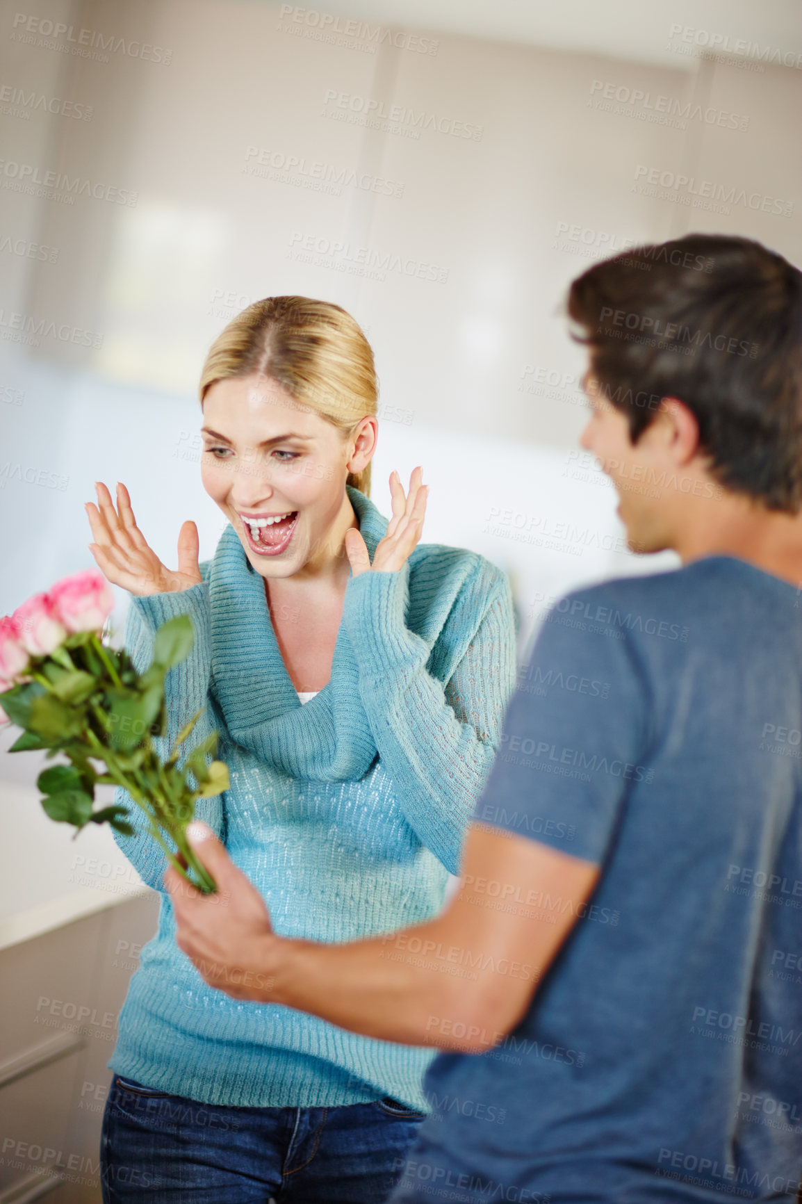 Buy stock photo Shot of an affectionate young man giving his beautiful young wife a bouquet of pink roses 