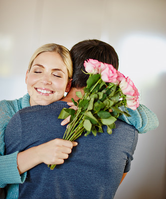 Buy stock photo Shot of an affectionate young man giving his beautiful young wife a bouquet of pink roses 