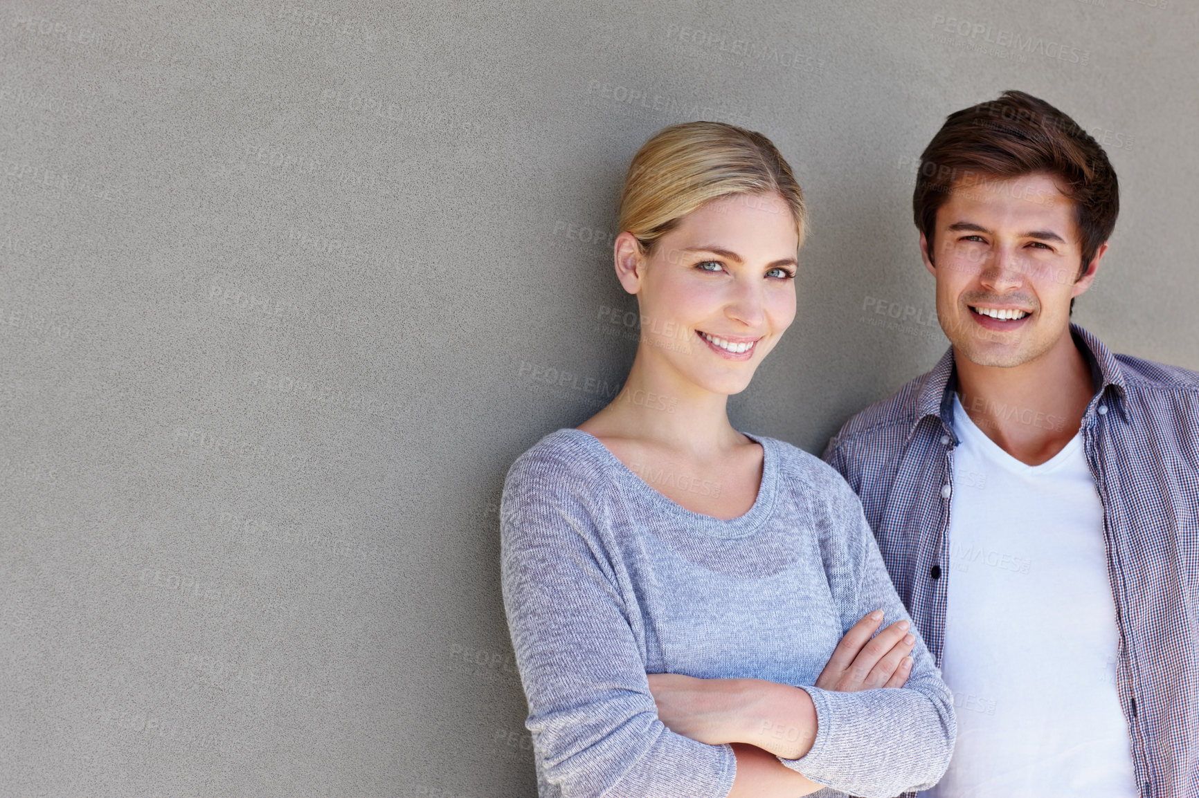 Buy stock photo Couple, portrait and happy on gray wall background for bonding, love and relationship outdoor. Man woman and face for care, date and connection with crossed arms, smile and mockup space outside