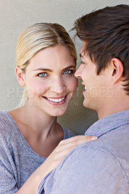 Buy stock photo Portrait of an affectionate young couple standing against a gray background