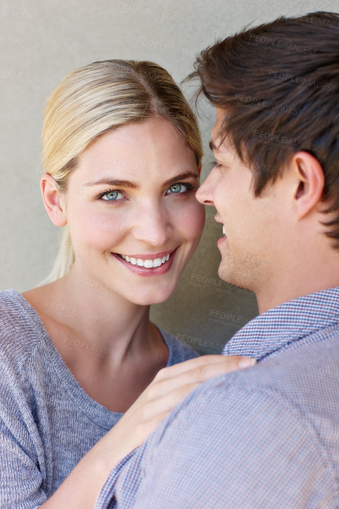 Buy stock photo Portrait of an affectionate young couple standing against a gray background