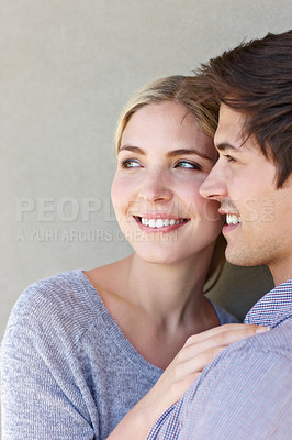 Buy stock photo Shot of an affectionate young couple standing against a gray background