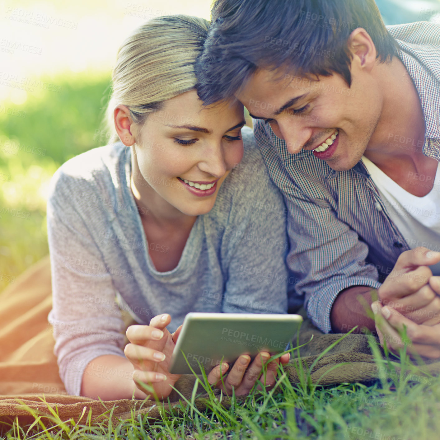 Buy stock photo Happy, grass and couple on tablet on picnic for online chat, social media and bonding on weekend. Relax, dating and man and woman on digital tech for internet, website and networking on park field